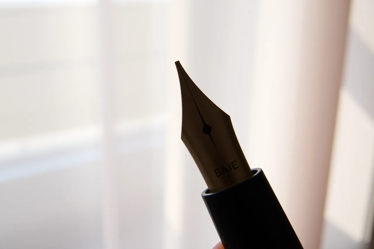 Macro of a fountain pen nib lit from the side by a curtained window (Fountain pen photography: lighting and backgrounds that work)